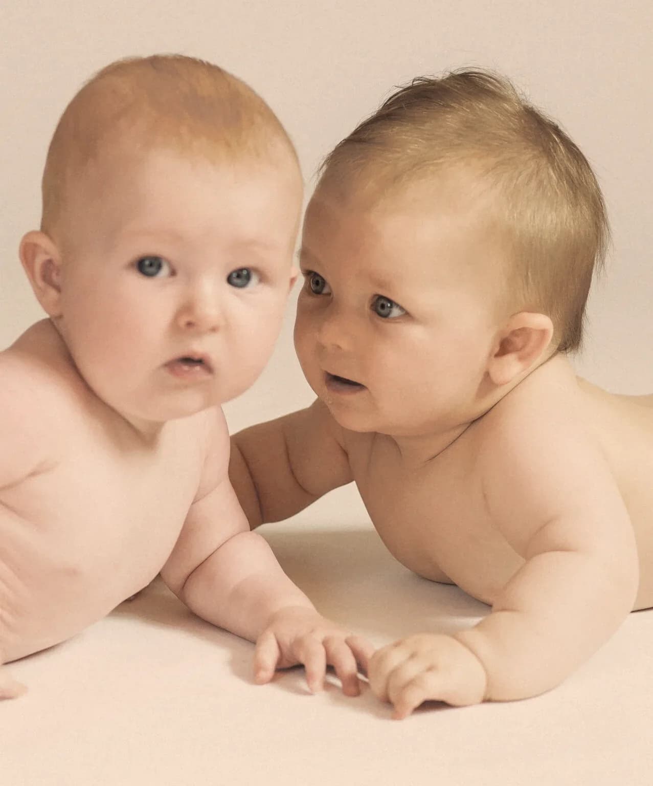 Zwei Babys nebeneinander in Bauchlage
